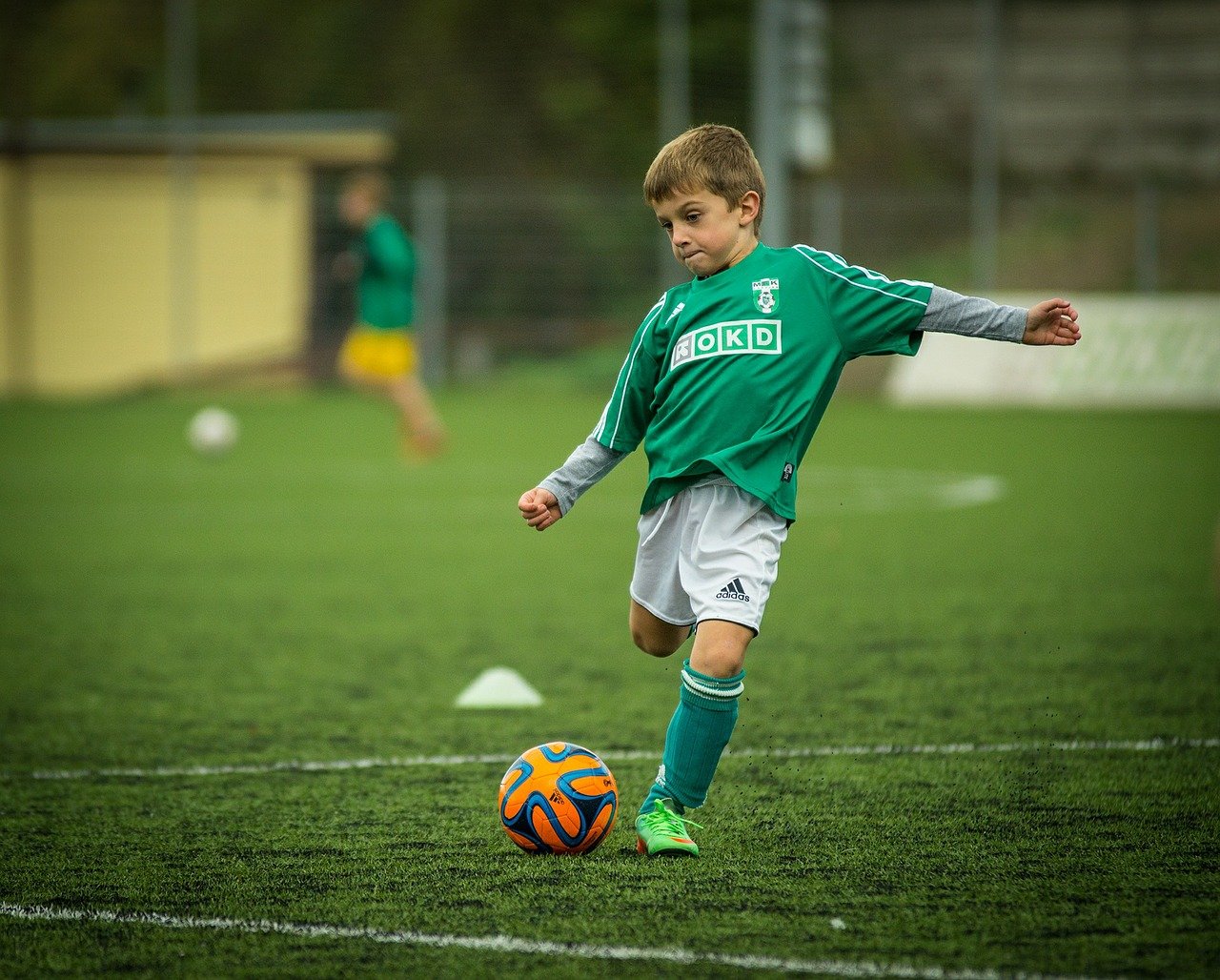 Sport im Kindesalter Junge spielt Fußball